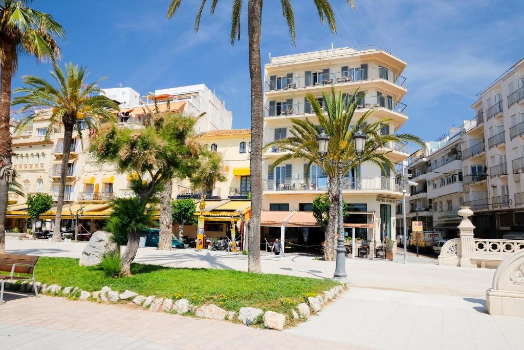 a city street with palm trees and buildings at Hotel Subur in Sitges