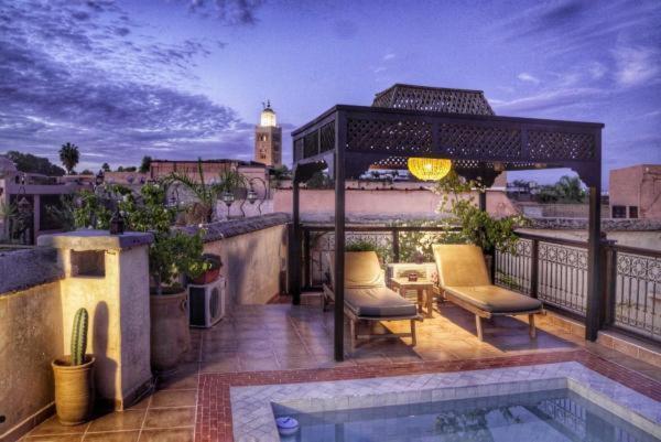 a balcony with a pool and a gazebo at Riad BB Marrakech in Marrakesh