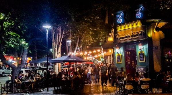 una multitud de personas caminando por una calle por la noche en La mejor ubicación y todo nuevo en Mendoza