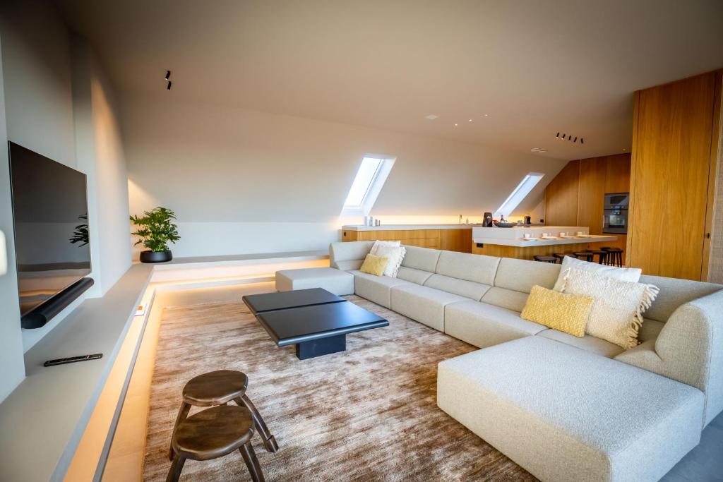 ein Wohnzimmer mit einem Sofa und einem Tisch in der Unterkunft The Penthouse Nami, Branding, Ultra Luxurious Japanese Design Sea View in Cadzand