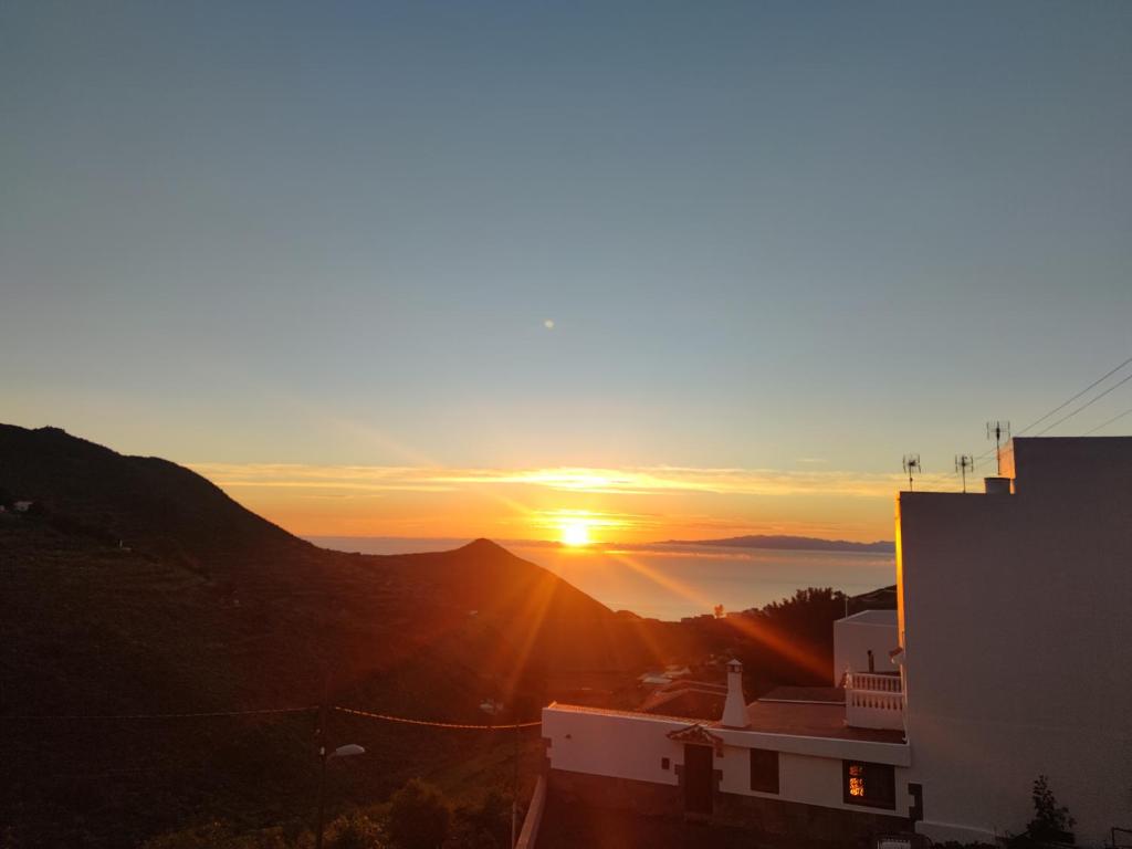 una puesta de sol sobre una montaña con la puesta de sol en El Rincón del Senderista en Santa Cruz de Tenerife
