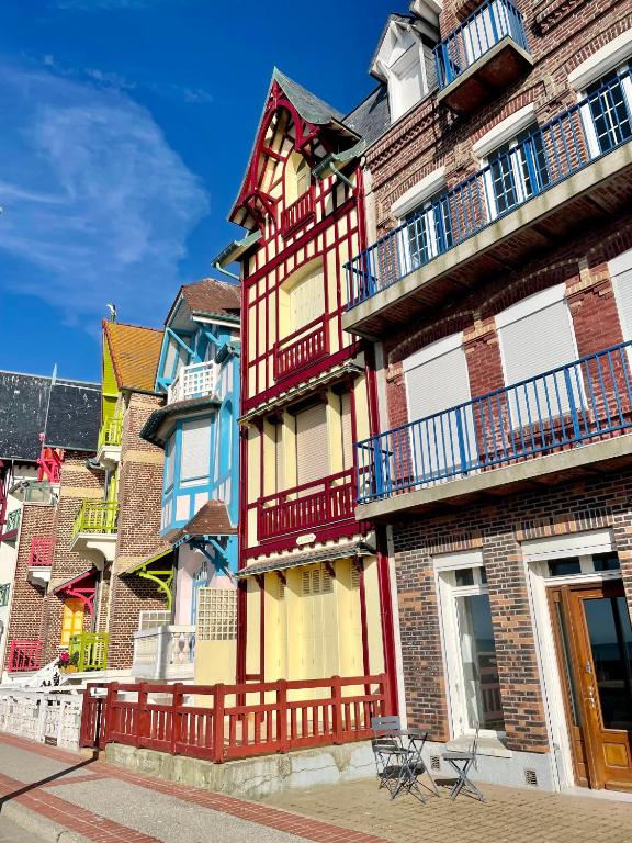 - un bâtiment avec balcon sur le côté d'une rue dans l'établissement Le Front de mer - studio lumineux esplanade Mers, à Mers-les-Bains