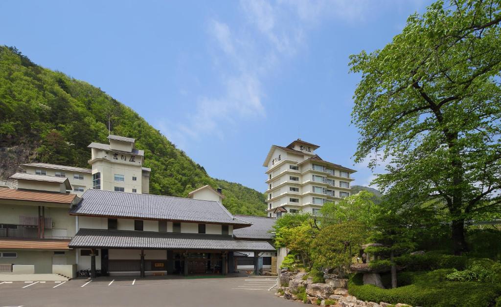 un grupo de edificios con una colina en el fondo en Yoshikawaya en Fukushima