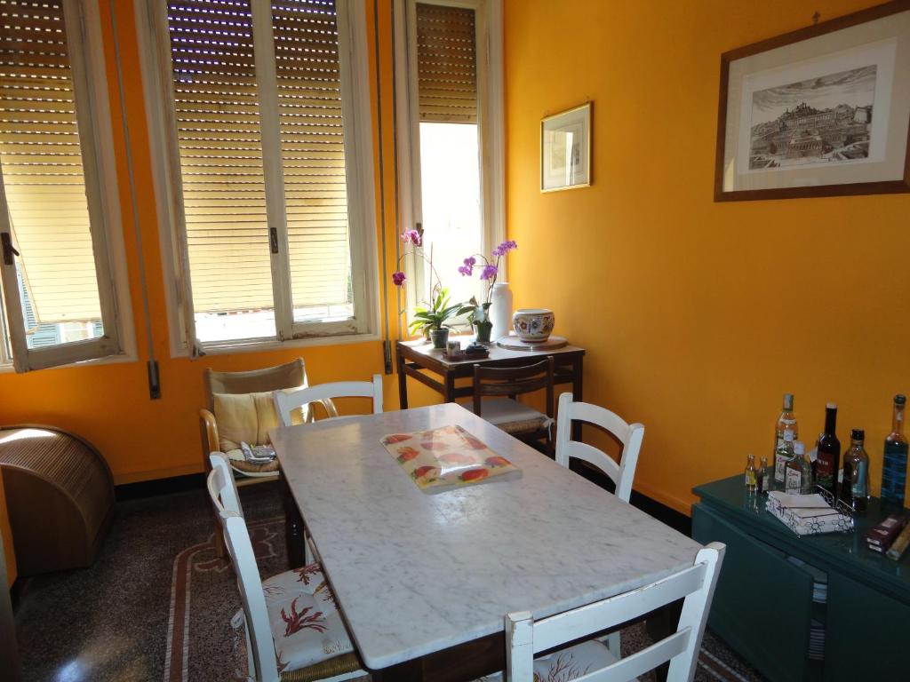 uma sala de jantar com uma mesa e cadeiras e paredes amarelas em Le Stanze del Notaio em Gênova