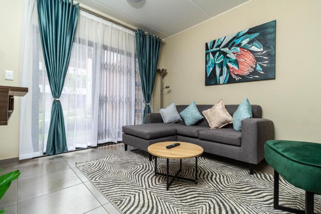 a living room with a couch and a table at The Lillies Luxury Apartment in Midrand