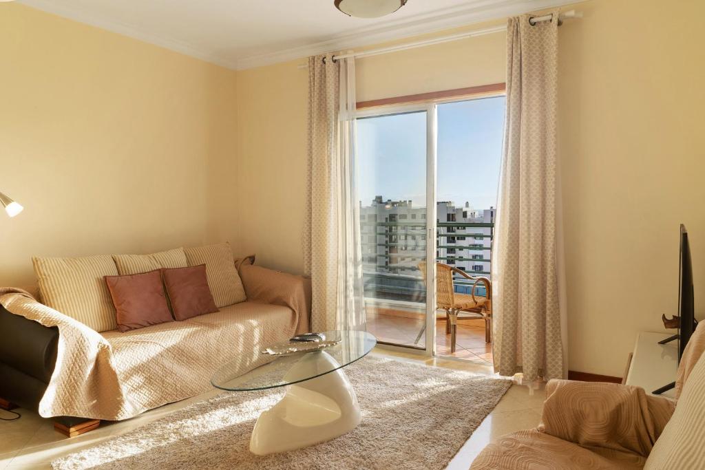 Una sala de estar con un sofá y una mesa de cristal. en Oliveira Atlantic View, en Funchal