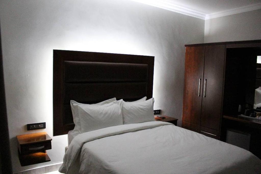 1 dormitorio con 1 cama grande y armario de madera en A pristine BB located in Belvedere Harare - 2006 en Harare