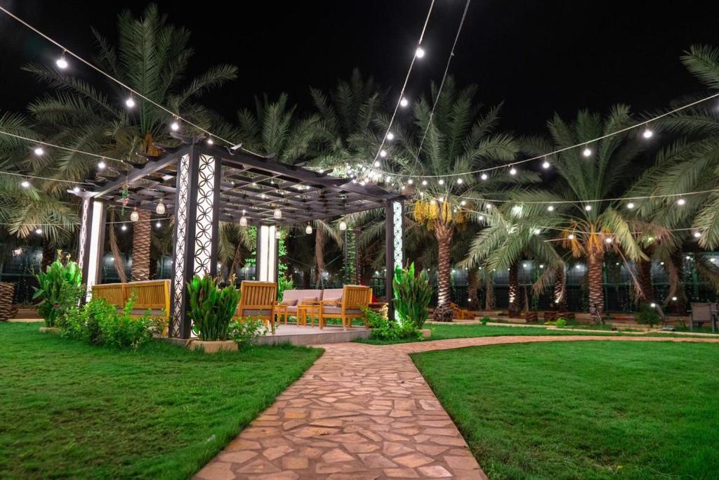 a pavilion with lights in a park at night at Ezdan Chalet in Unayzah