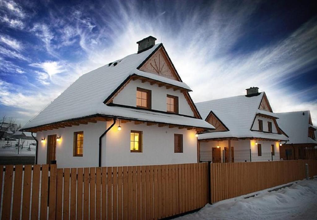 ein weißes Haus mit Schnee drauf in der Unterkunft Domki pod Tatrami in Zakopane