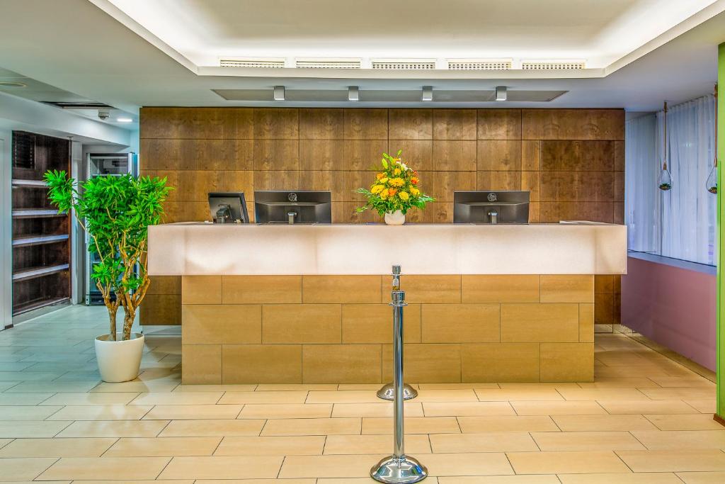 a lobby with a counter with flowers on it at Quality Hotel Vienna in Vienna