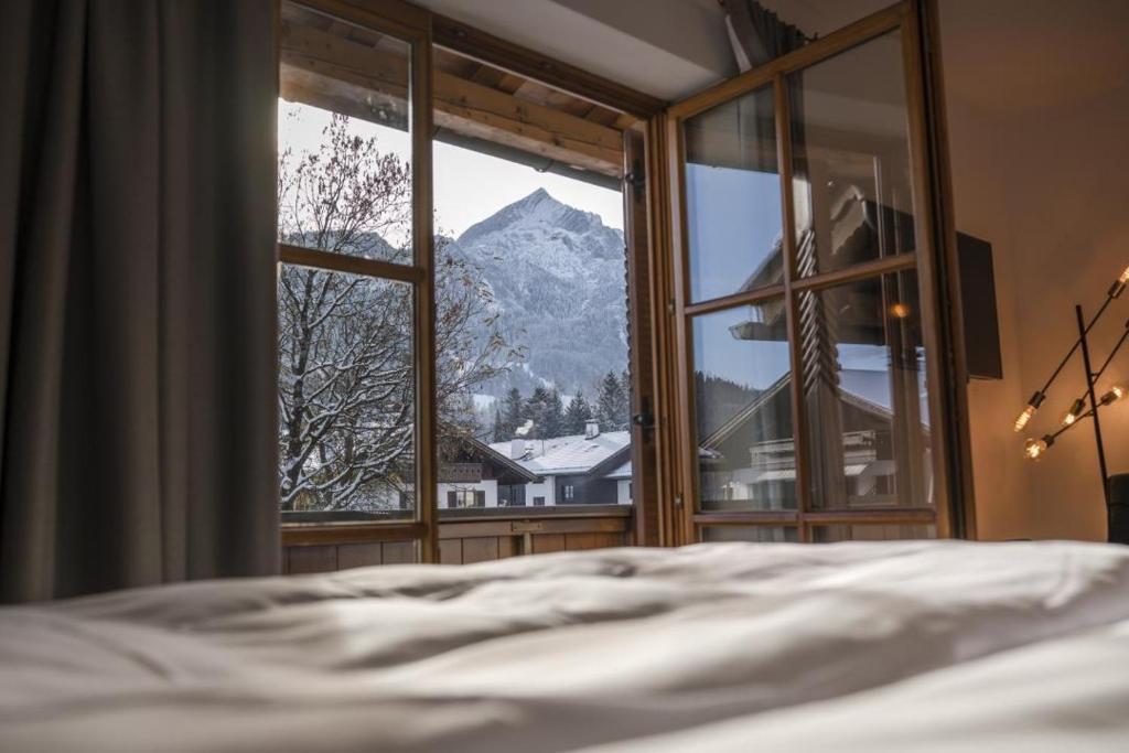 Schlafzimmer mit Bergblick durch ein Fenster in der Unterkunft Ferienhaus Die 14 mit Infrarotkabine in Garmisch-Partenkirchen