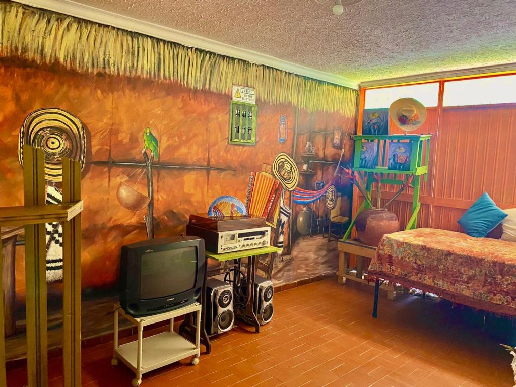 um quarto com um mural de um quarto com uma televisão em Hotel Casa La Pilonera em Valledupar