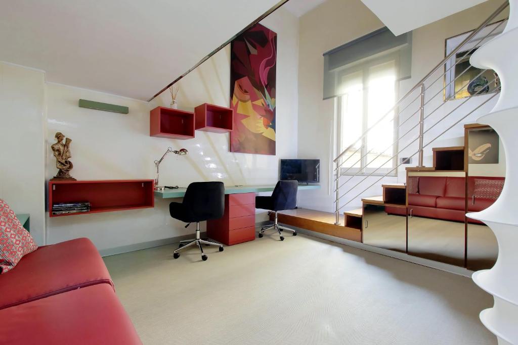 a living room with a red couch and two chairs at Loft Margutta per Smart Worker in Rome