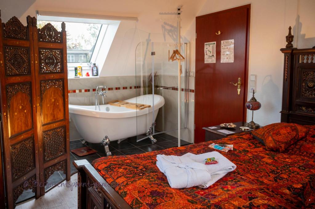 uma casa de banho com uma banheira e uma cama e uma banheira em Berlin entspannt geniessen em Berlim