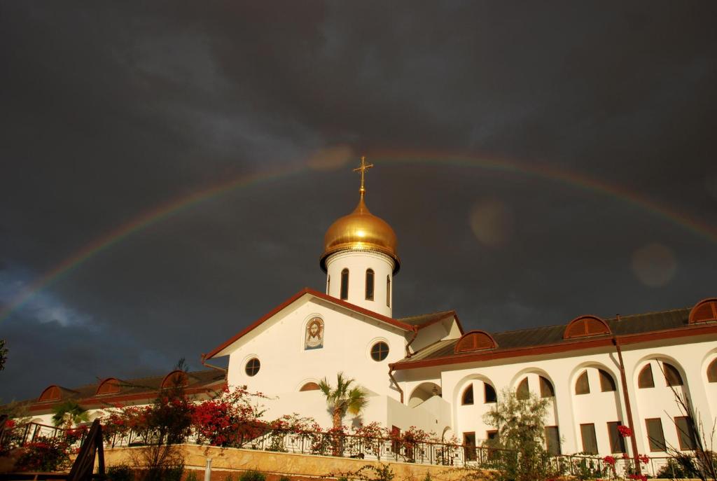a rainbow over a building with a church at Russian Pilgrim Residence in Sowayma
