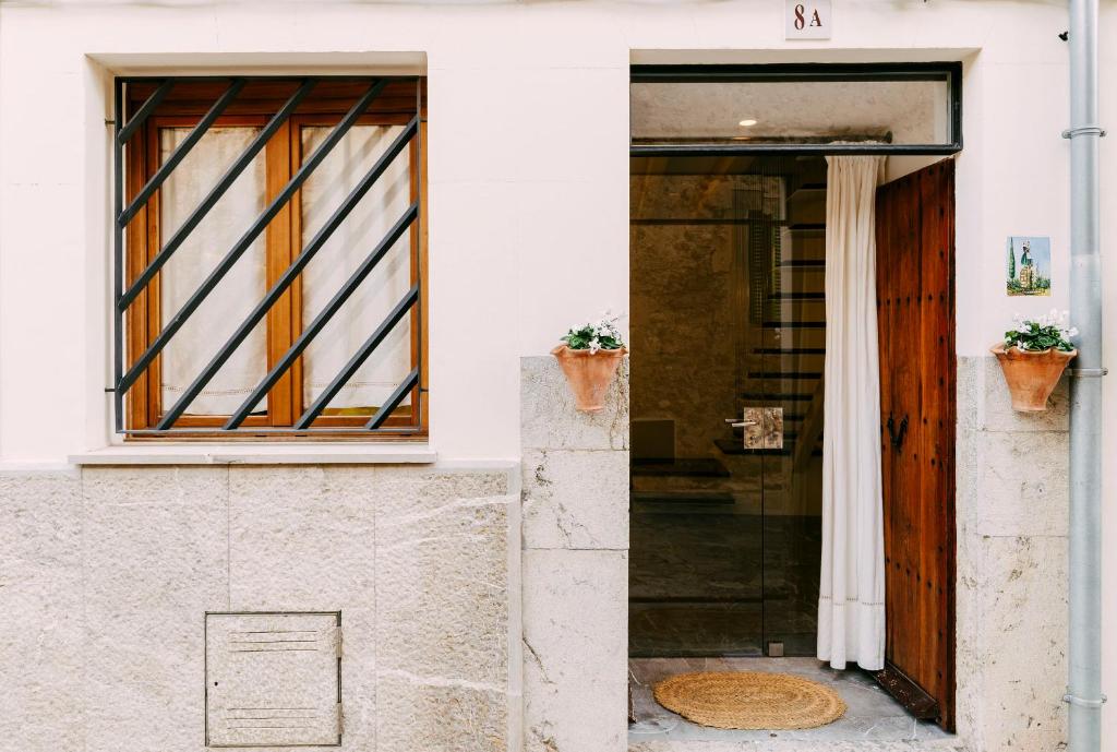 an open door of a white house with two potted plants at Casa Rei Sanxo, 8A in Valldemossa