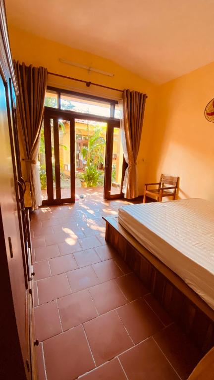 um quarto com uma cama e uma grande janela em Duke Bungalow em Phu Quoc