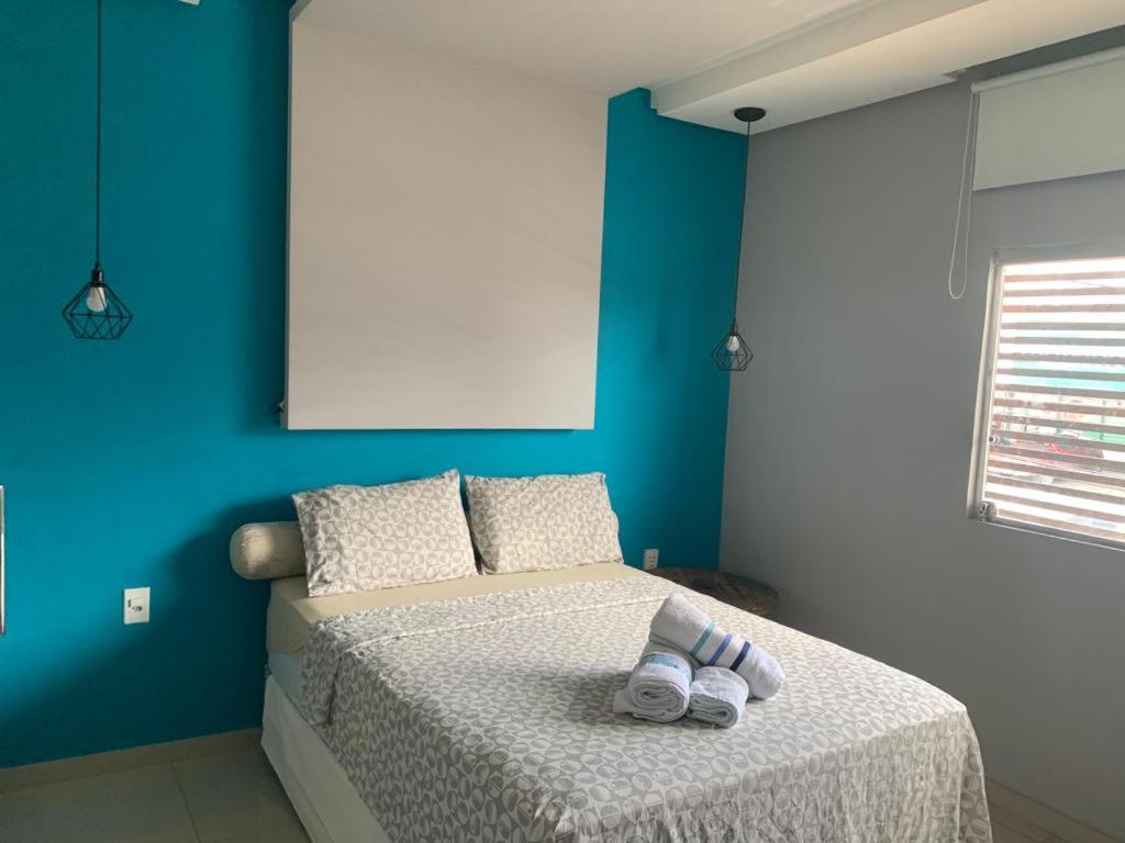 een blauwe slaapkamer met een bed met slippers erop bij #01 Boulevard Amazon Suites in Manaus