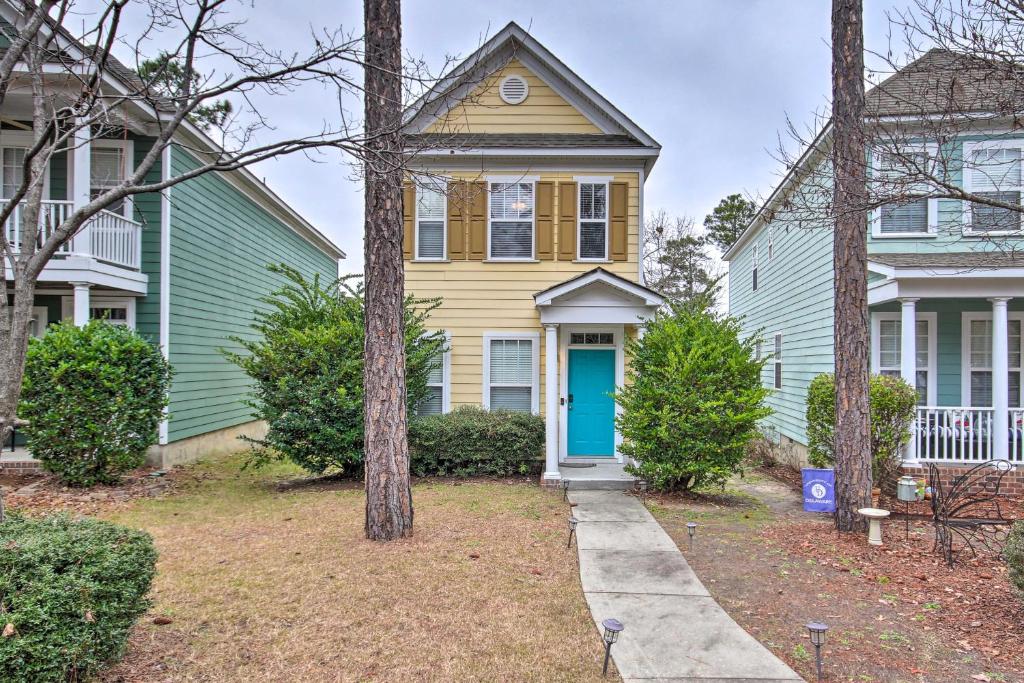 una casa amarilla y verde con una puerta azul en Veteran-Owned Family Home Near Fort Jackson! en Columbia