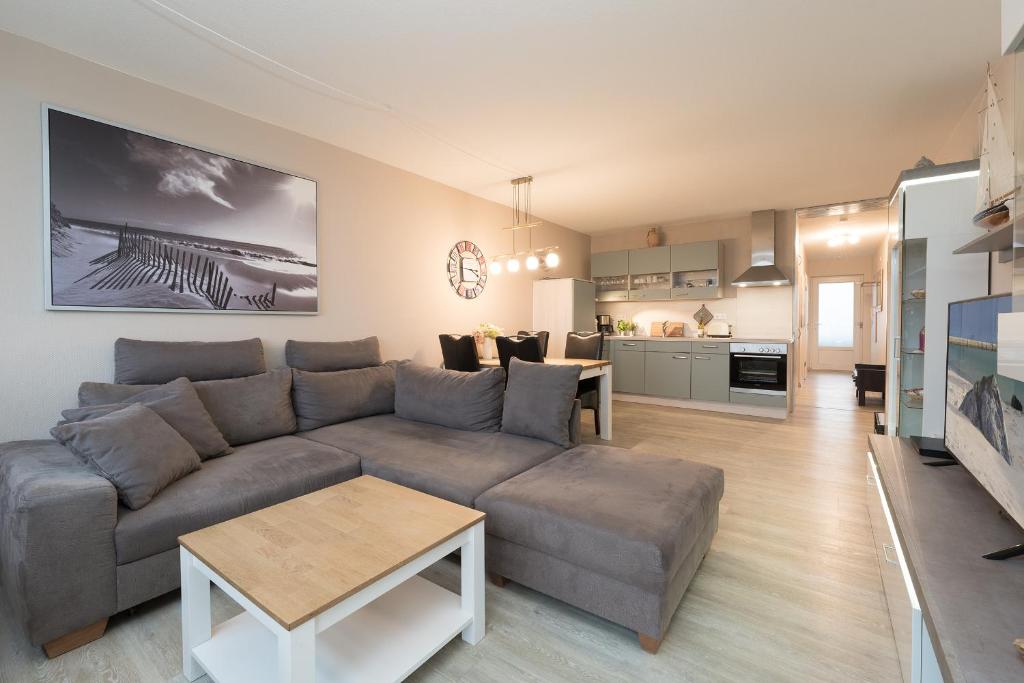 sala de estar con sofá gris y cocina en Driftberg 1 _Meeresbrise_, en Grömitz