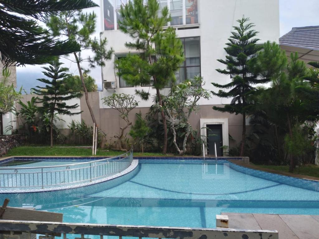 ein Schwimmbad vor einem Gebäude in der Unterkunft Villa Adinda Syariah D8 in Tarogong