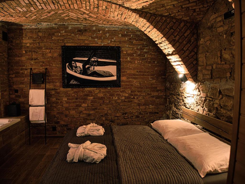 una camera con un letto in un muro di mattoni di Wellness Gallery Apartments a Liberec
