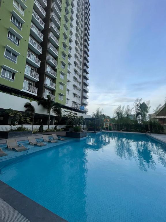 a large swimming pool next to a tall building at Mesatierra Garden Residences in Davao City