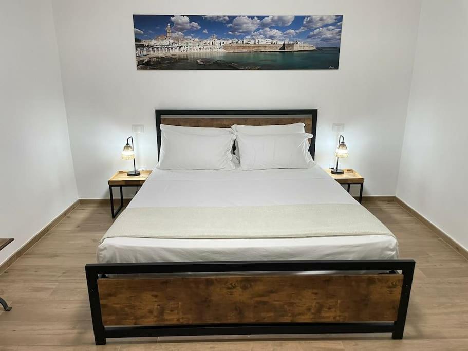 una camera da letto con un letto grande con due comodini di Casetta di Gaia a Monopoli
