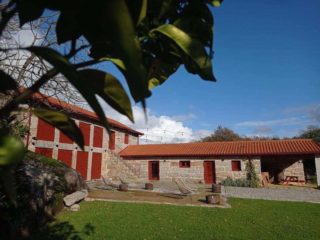 einem rot-weißen Gebäude mit Stühlen davor in der Unterkunft Quinta Pousada de Fora in Guimarães