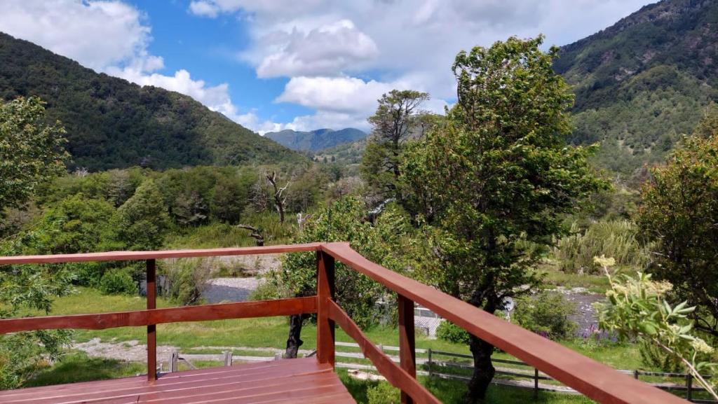 a wooden deck with a view of the mountains at Cabañas Estero Caracoles Malalcahuello in Malalcahuello