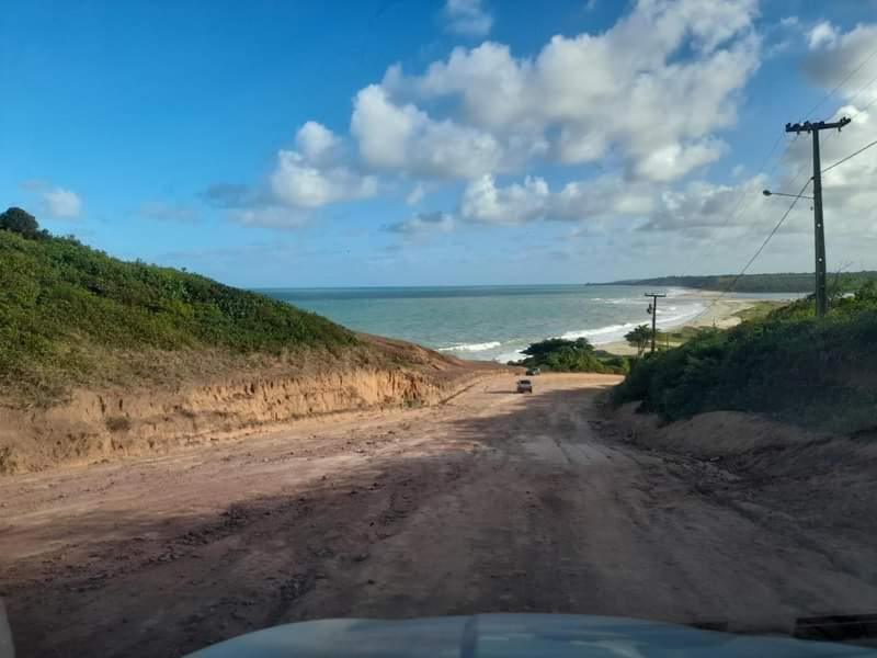 un camino de tierra junto al océano en una playa en Pousada caminho das praias jp en João Pessoa