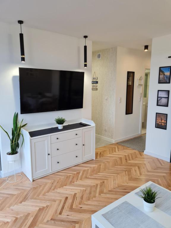 a living room with a large television on a wall at Gdynia Główna Apartament in Gdynia
