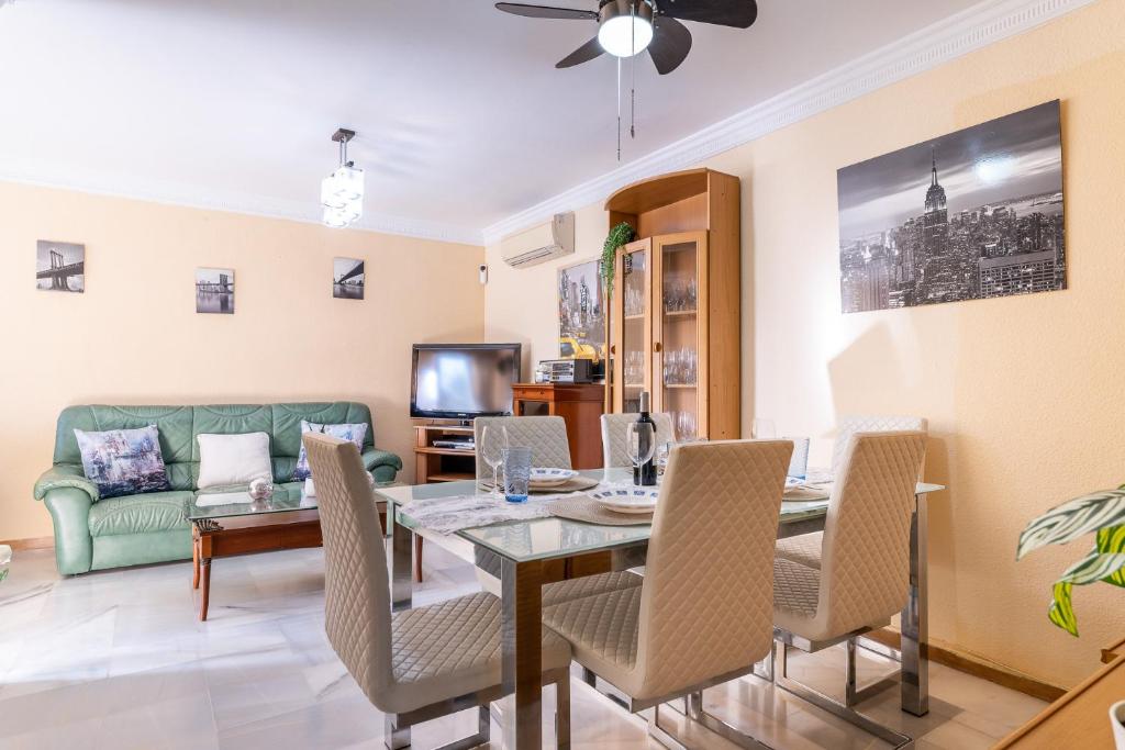 sala de estar con mesa, sillas y sofá en MalagaSuite Sotomar Apartment, en Torremolinos