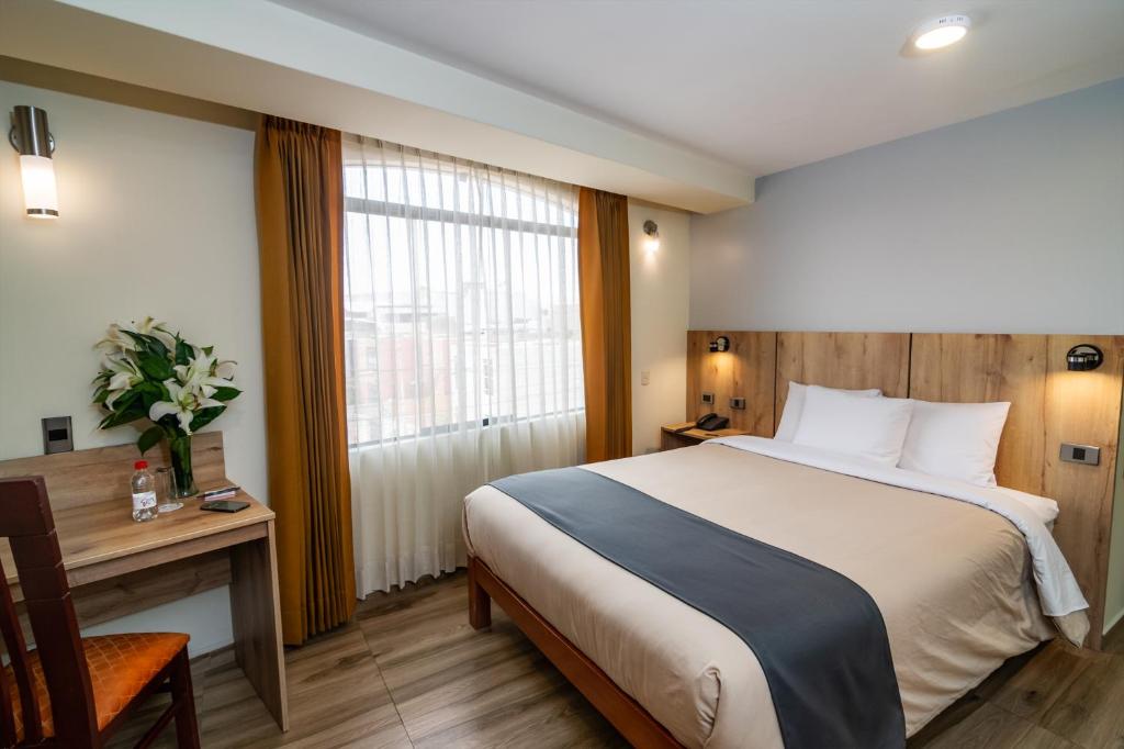 a hotel room with a bed and a desk and a window at Casa Villa Arequipa in Arequipa