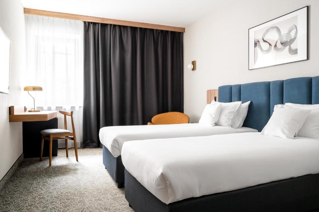 Pokój hotelowy z 2 łóżkami i biurkiem w obiekcie Dwór w Tomaszowicach w mieście Modlnica