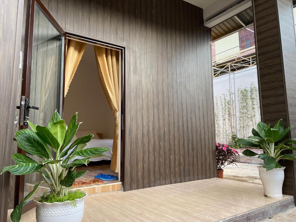 Zimmer mit zwei Topfpflanzen und einem Schlafzimmer in der Unterkunft Pleiku Homestay in Pleiku