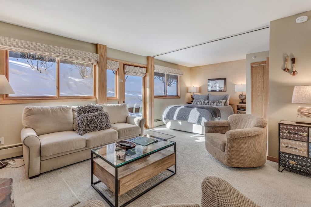 un soggiorno con letto, divano e tavolo di Laurelwood Condominiums 402 a Snowmass Village