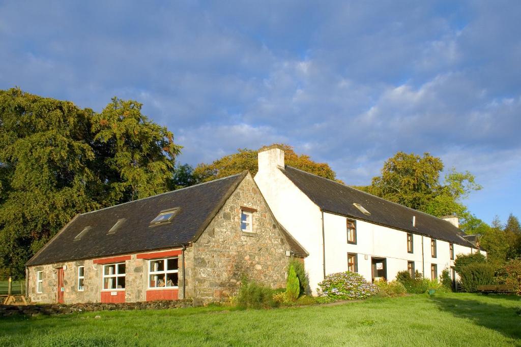 un grand bâtiment blanc avec un toit noir dans l'établissement Ratagan Youth Hostel, à Kintail