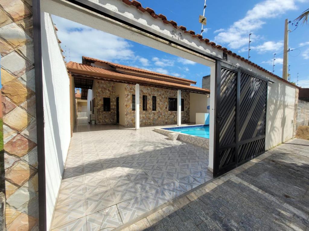 an open door to a house with a swimming pool at Casa em Peruíbe in Peruíbe