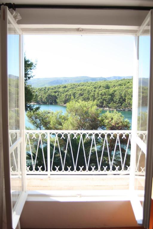 a window with a view of the water at Apartment Bugenvila in Vrboska