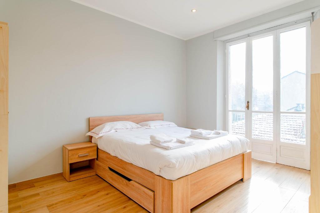 biała sypialnia z łóżkiem i dużym oknem w obiekcie WHITE HOME - METRO MASSAUA w Turynie