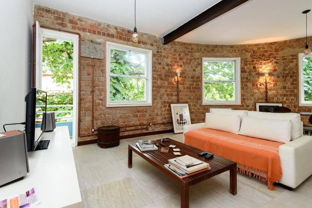 uma sala de estar com um sofá e uma mesa em Varanda a 500m da praia de Ipanema e 100m da Lagoa no Rio de Janeiro
