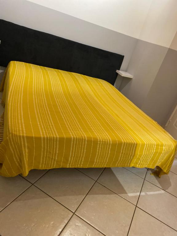 un lit jaune avec une tête noire dans l'établissement Les gites du pont de Reynes, à Reynès