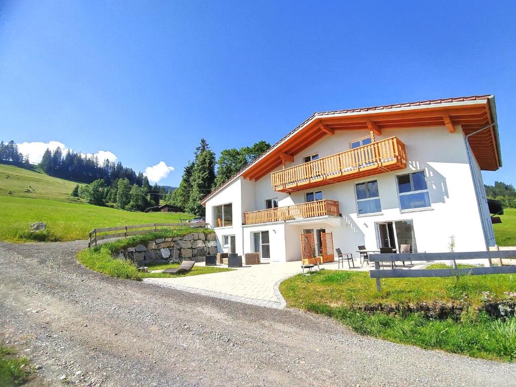 a large white building with a balcony on a hill at Landhaus am Schindelberglift in Oberstaufen