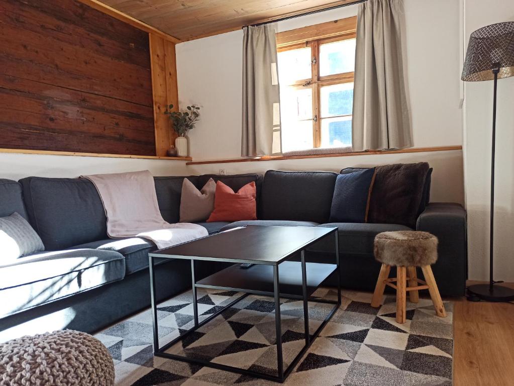 een woonkamer met een blauwe bank en een tafel bij Haus Barbara in Wald am Arlberg