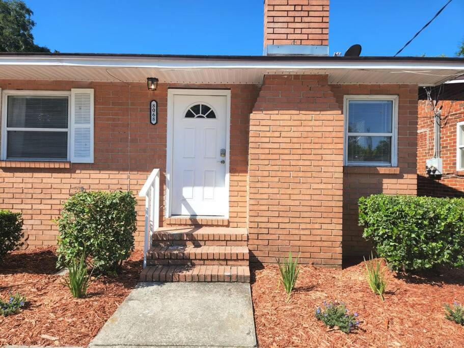 a brick house with a white door and stairs at King Bed 2bed1bath Sleeps 5 Close To Town Center Downtown Beach Mayo Clinic New in Jacksonville