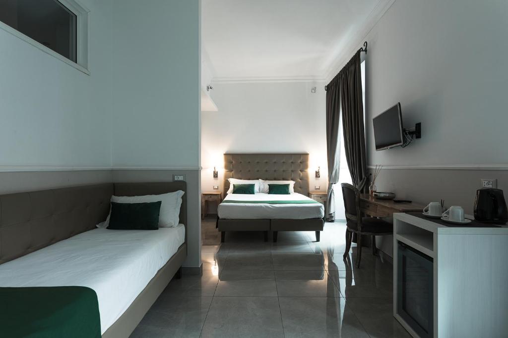 a bedroom with a bed and a desk and a television at Vaticano Luxury Guest House in Rome