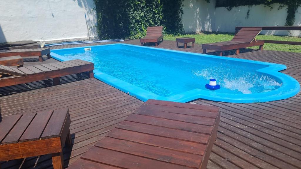 una piscina en una terraza con bancos y sillas en Hotel Dos Reyes en Villa Gesell