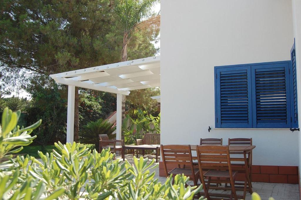 a patio with chairs and a white pergola at Petruso Resort in Balestrate