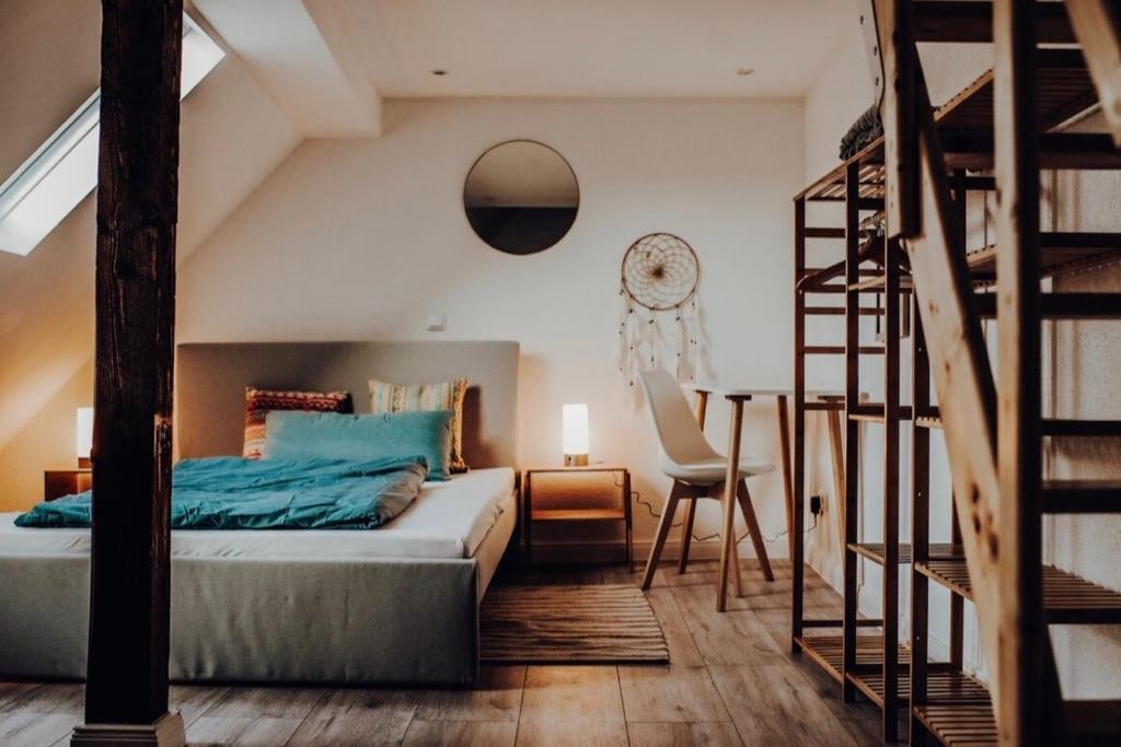 Schlafzimmer mit einem Bett mit blauer Bettwäsche und einer Leiter in der Unterkunft Mayen, Bäckerstr, Privatzimmer Nr3, Innenstadt, nähe Nürburgring & Burg Eltz, Gemeinschaftsbad in Mayen